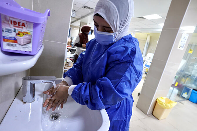 A healthcare worker using a water-saving faucet